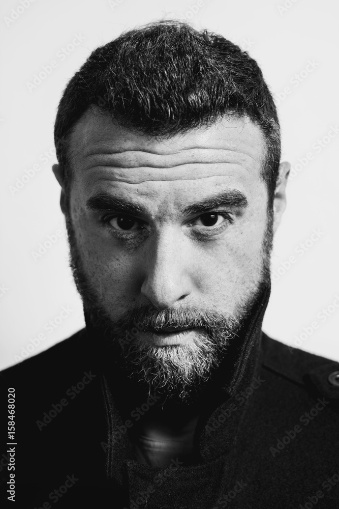 Obraz premium Portrait of a young handsome bearded model. Black and white photo. 