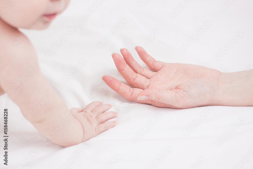 Close up picture of four month kid and his mother hands Close up picture of four month kid and his mother hands