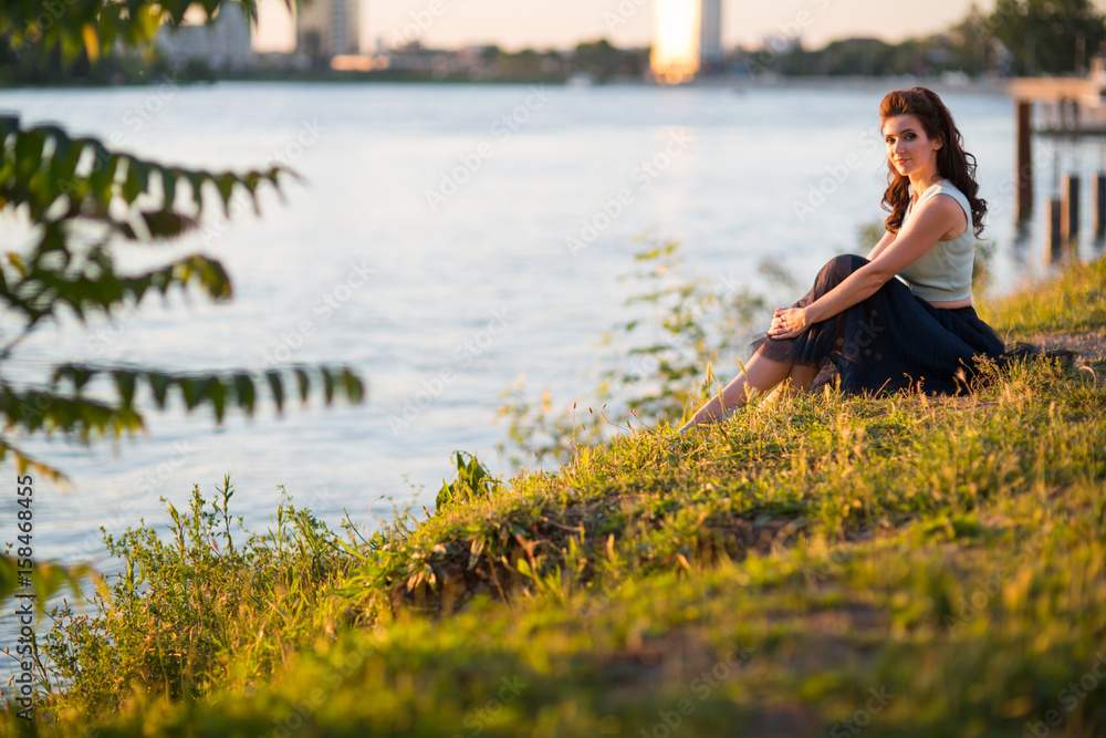 young woman sits on the river young woman sits on the river