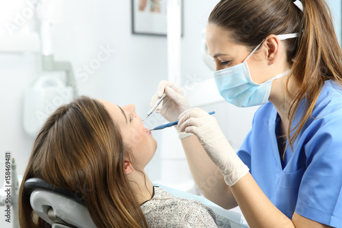 Dentist examining patient teeth at office photo