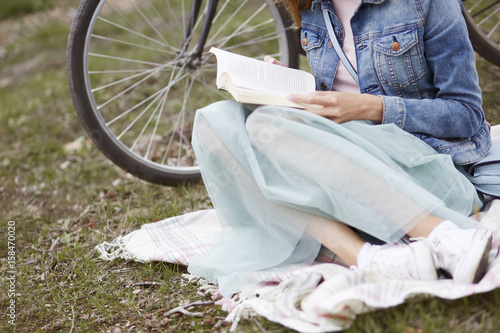 Low section of woman which reading a book outside