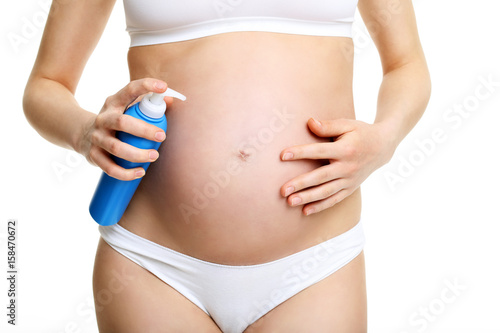 Pregnant woman with anit stretch marks cream over white background