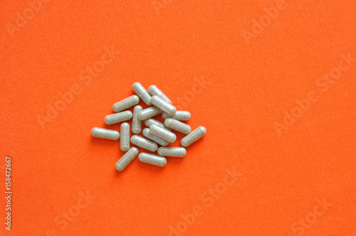 Pile of brown pills, on orange background