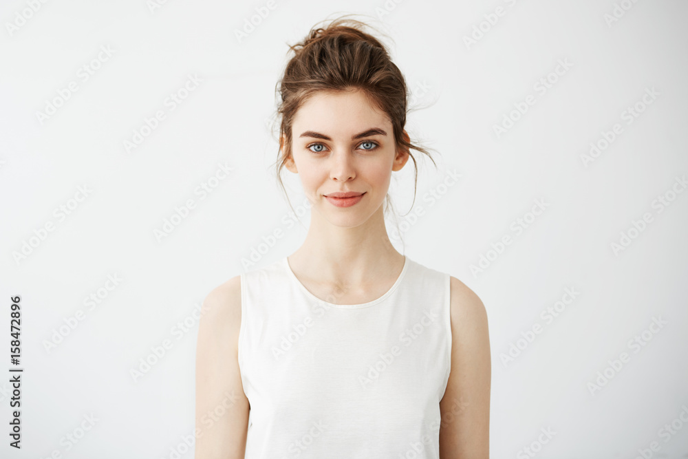Obraz premium Portrait of young beautiful brunette girl smiling looking at camera over white background.