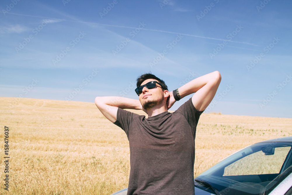 Hombre joven con gafas de sol disfrutando de un día de verano en el campo  Stock Photo | Adobe Stock