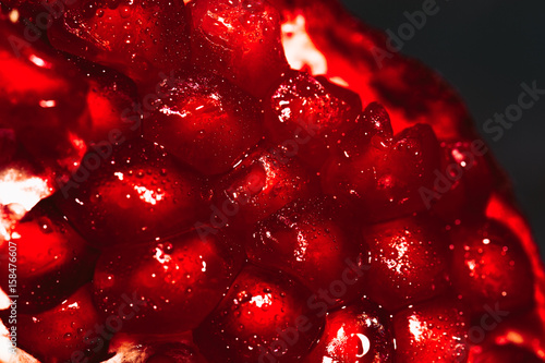 red sliced pomegranate on a blue abstraction background close up