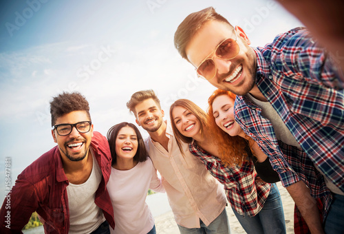 Group of young people having fun outdoors on the beach  photo