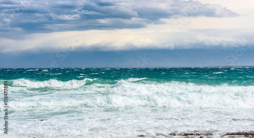 Strong wind  sea waves and the coast or beach.