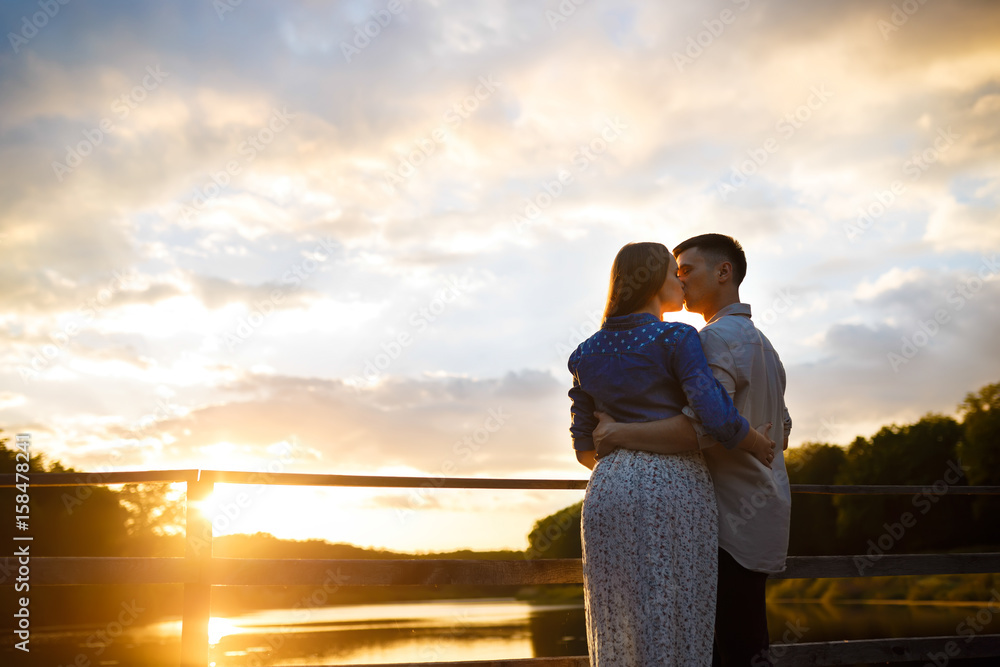 Cuddling couple. Couple in love. Love couple. Love hug. Love kiss. Couple kiss. Sunset 
