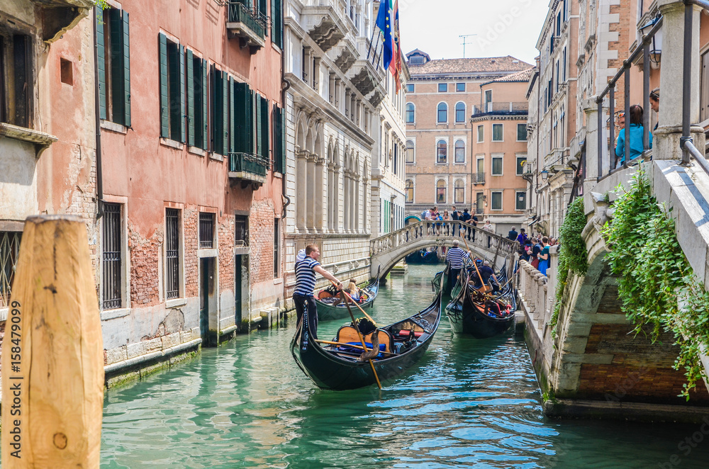 Venice Italy, gondola passing beneath a bridge.