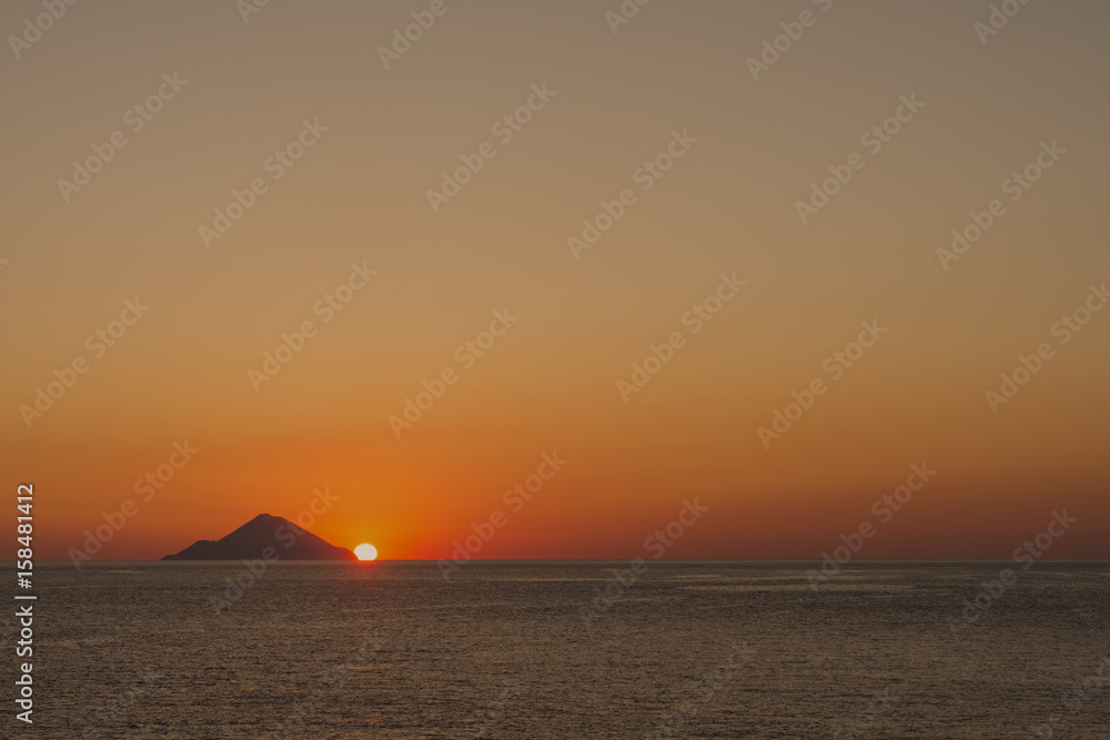 Il sole tramonta dietro l'isola di Filicudi, arcipelago delle Isole Eolie IT	