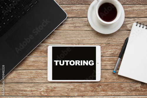 Tablet on desktop with tutoring text.