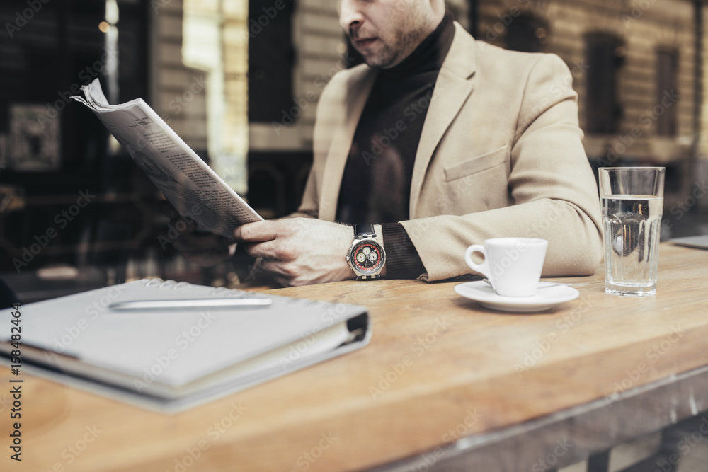 Handsome elegant Caucasian businessman sitting at coffee shop and reading newspapers. Handsome elegant Caucasian businessman sitting at coffee shop and reading newspapers.