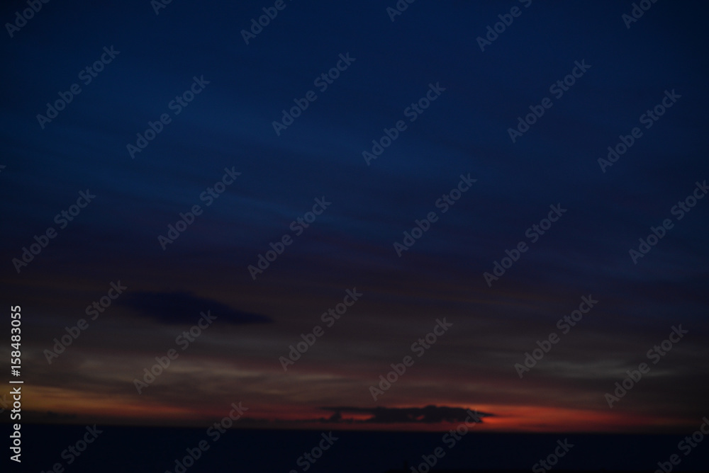 Abstract blurred dawn light shining through dark clouds background. Natural cloudscape skyline