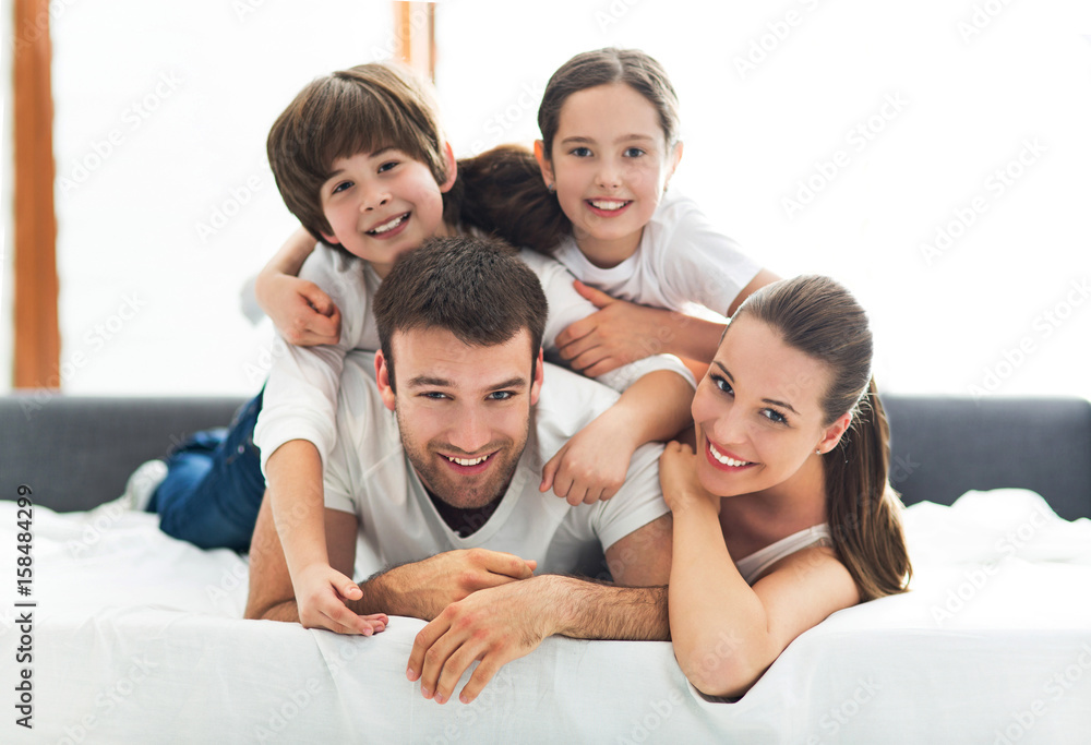 Family of four lying on bed
