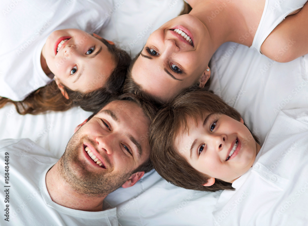 Family of four lying on bed
