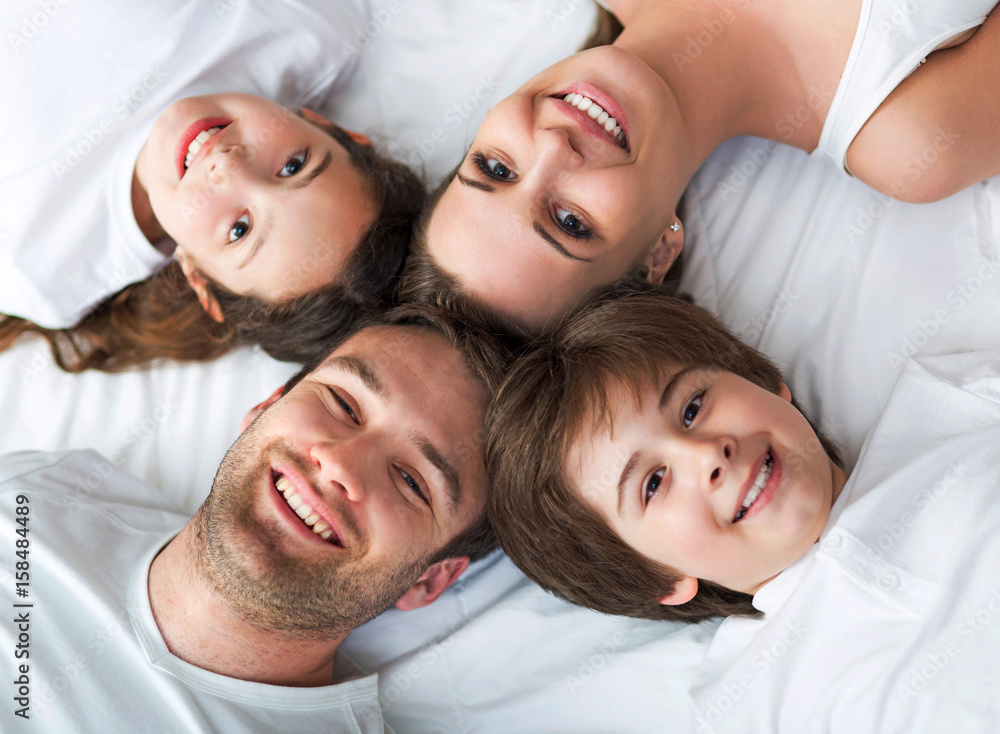 Family of four lying on bed
Family of four lying on bed
