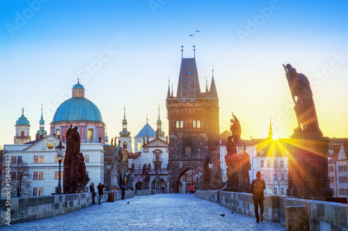 Charles bridge sunrise scenery, sun rays visible. Prague iconic travel destination, Czech Republic. 