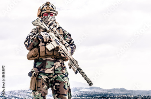 Sniper stand with rifle and scope look around photo