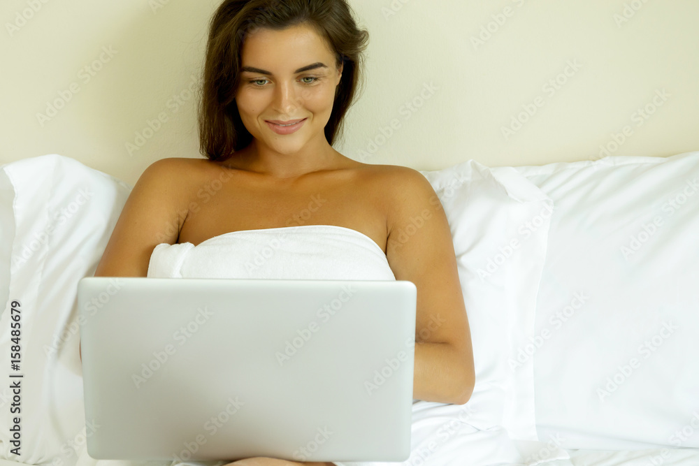 Woman lying on the bed and using laptop pc Woman lying on the bed and using laptop pc