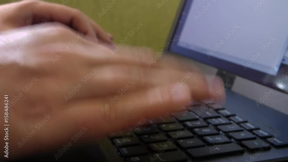 Caucasian man hands printing on laptop keyboard. Closeup view of computer with green wall behind. Office scene. Caucasian man hands printing on laptop keyboard. Closeup view of computer with green wall behind. Office scene.