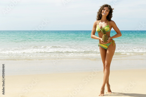 Woman with a pineapple fruit on the beach © blackday
