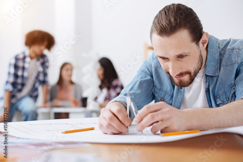 Clever scrupulous guy using special tool for drawing