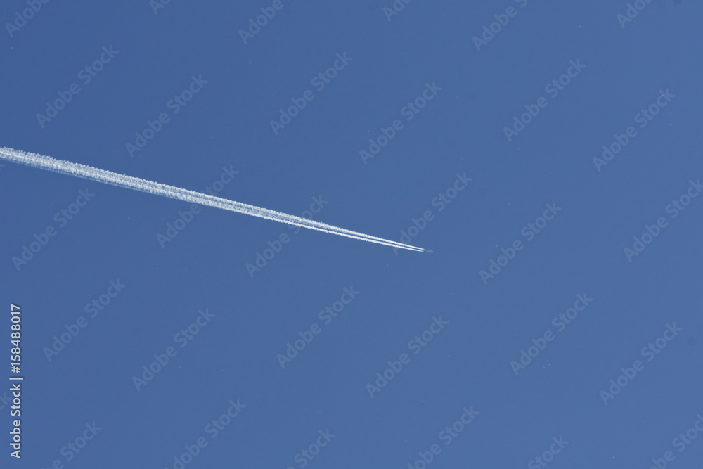 Airplane condensation trail going on blue sky Airplane condensation trail going on blue sky