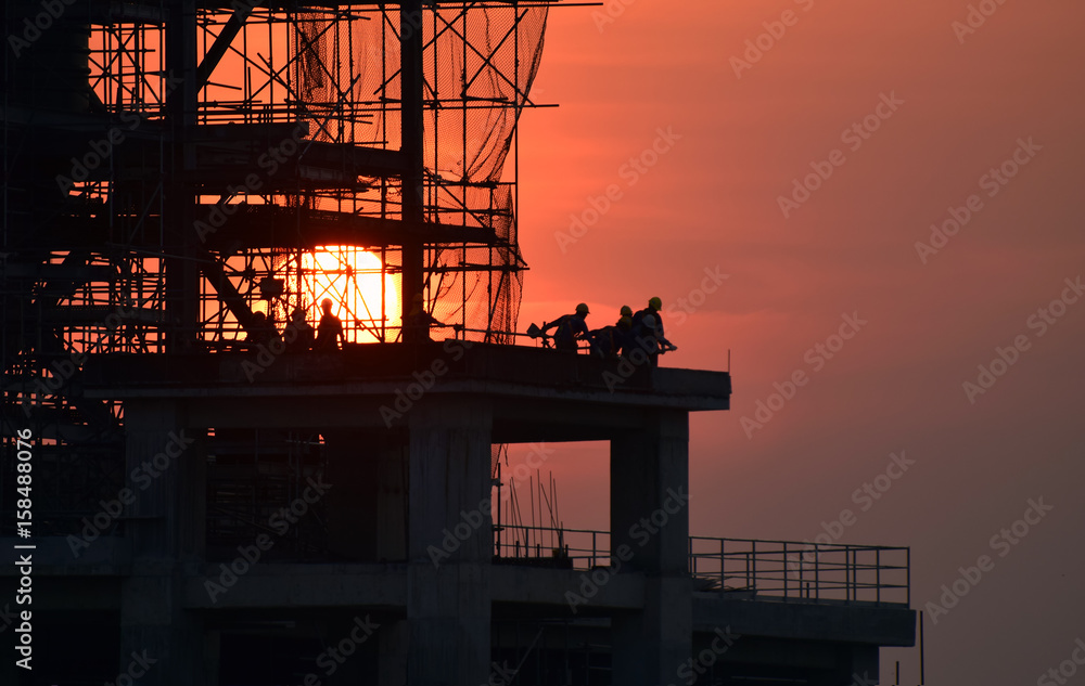 construction site and sunset , structural steel beam build large residential buildings at construction site . 