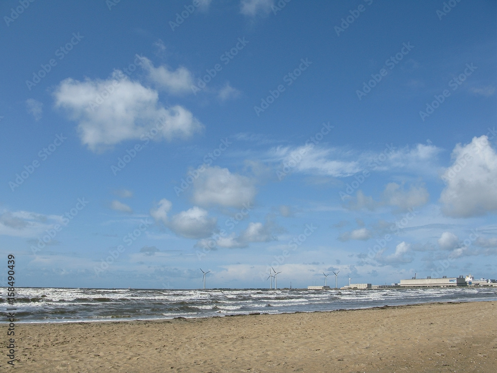 Sandy beach at Skrea Strand on a windy and sunny day with dark clouds in Falkenberg, Sweden.