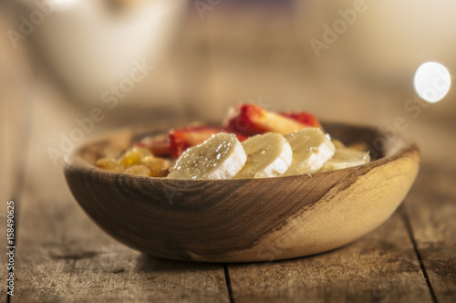 oatmeal porridge with strawberry and banana in wood bowl photo