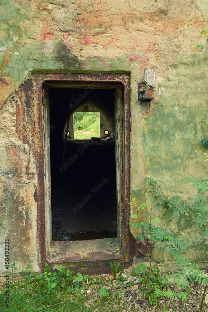entrance to an abandoned military base in the woods entrance to an abandoned military base in the woods