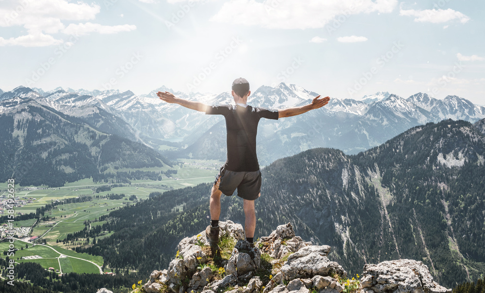 Obraz premium Bright sunlight near hiker on mountain top