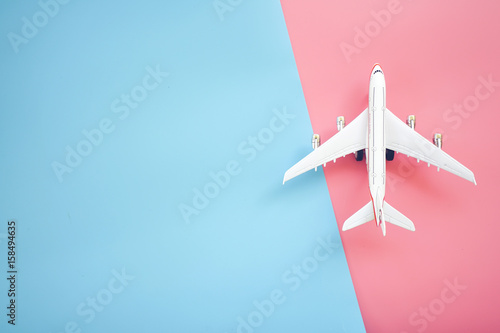 Fototapeta Mieszkanie świecki projekt koncepcji podróży samolotem na niebieskim i różowym tle z miejsca kopiowania.