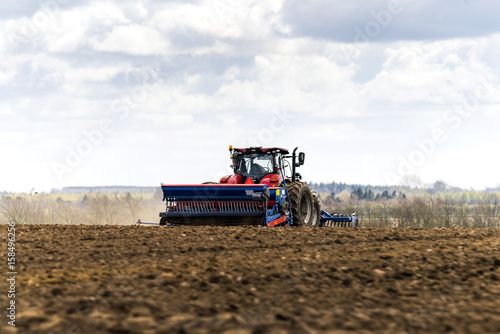 Red tractor driving on a field