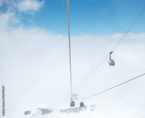 .Cabin of ropeway in mountains among clouds in the sky