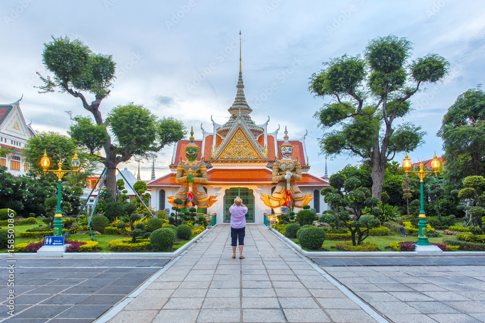 Traveler selfie and take a photo two statue giant at churches Wat Arun, Bangkok, Thailand
