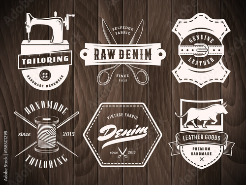 Tailoring denim labels. Set of vintage logos for tailoring, leather and denim shops on a wooden background. Vector retro style badges