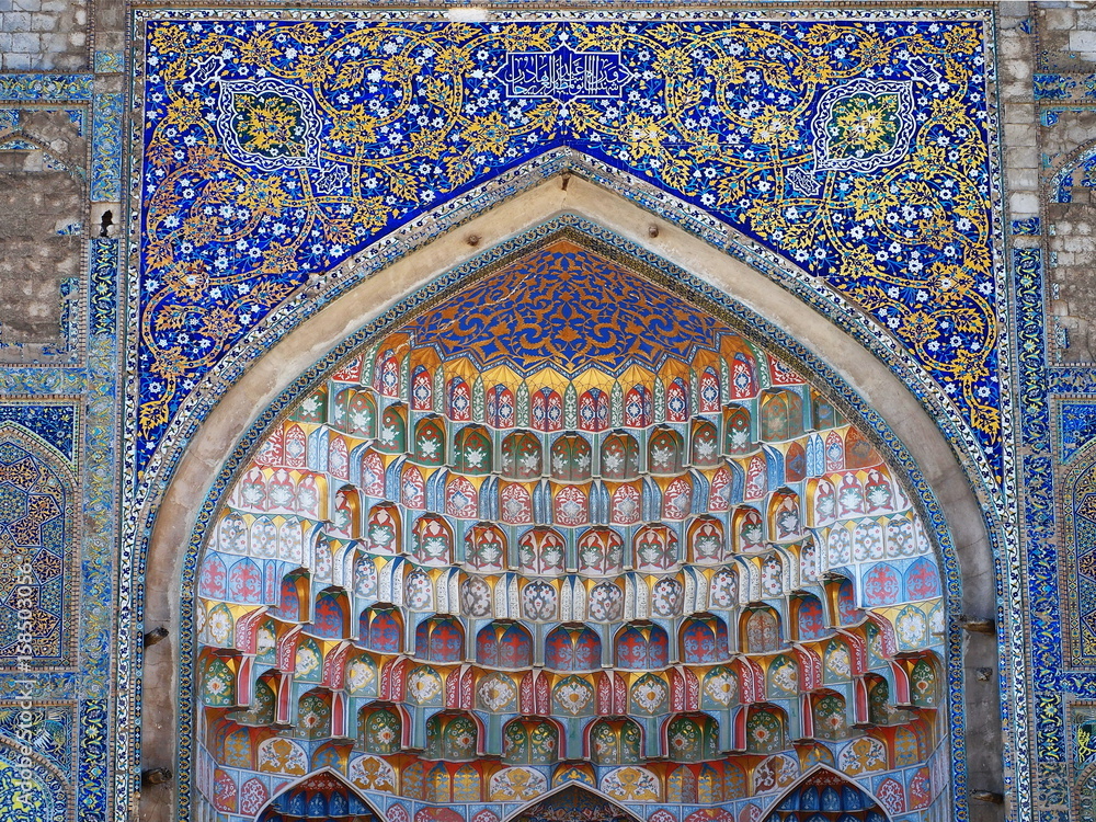 Farcade details of Abdulaziz Khan Madrassa in Bukhara, Uzbekistan. Decorative patterns  and architectural detail of luxirous decoration found on main entrance