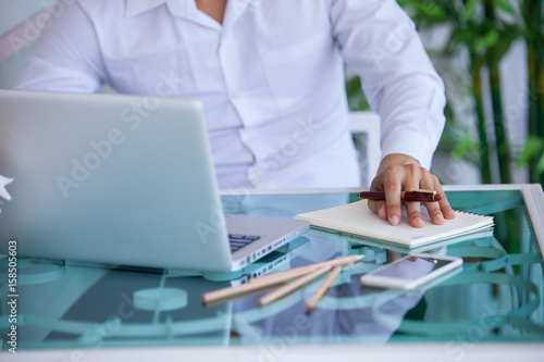 Middle aged businessman working from home using laptop at kitchen table