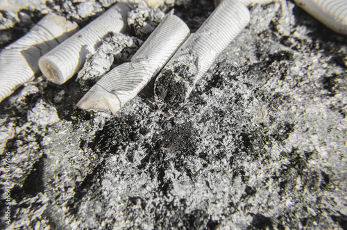 Close up on many cigarette butts and ashes