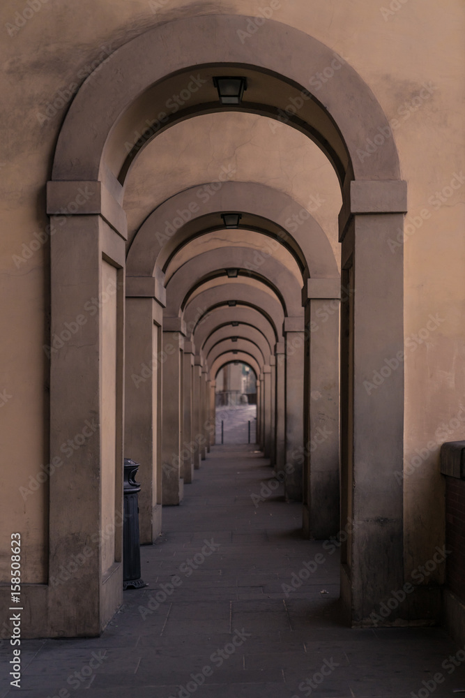 Series of arches along the Arno River in Florence with gradual fading focus.