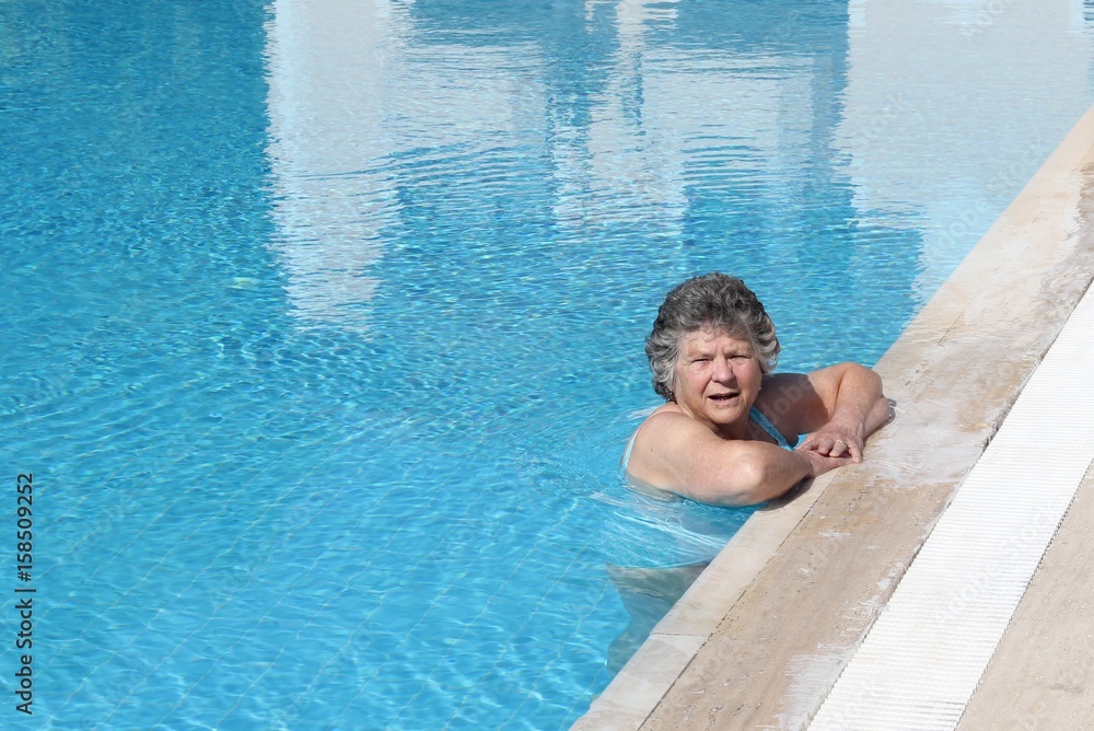 A retired lady cooling off in a swimming pool while on vacation, 2017