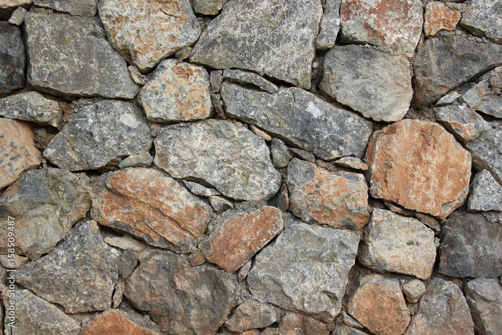 An old brown and grey colors stone wall background.