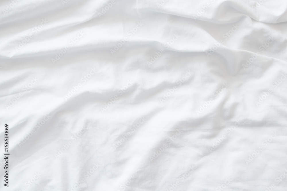 Top view of unmade bedding sheets or white fabric wrinkle texture background