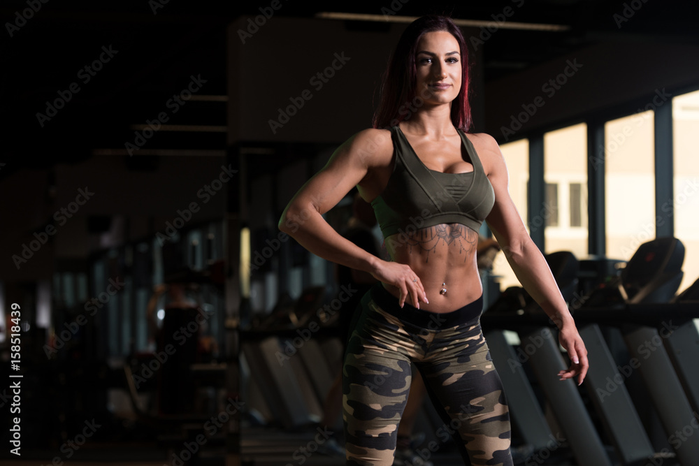 Attractive Muscular Woman Flexing Muscles In Gym