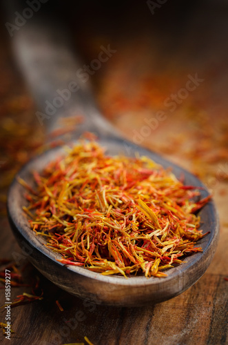 Dried Spice Saffron In A Wooden Spoon On A Board. Rustic. Dark Style. Still Life. Close-Up. Macro. Shallow Depth Of Field. Free Space For Text.