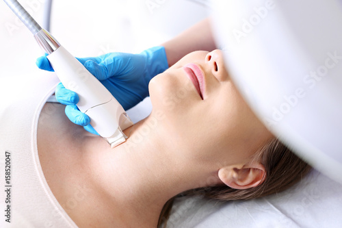 Fotoodmładzanie skóry szyi. Kobieta w klinice medycyny estetycznej na zabiegu laserowego odmładzanie skóry.
