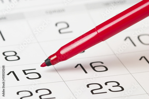 Red pen over calendar
