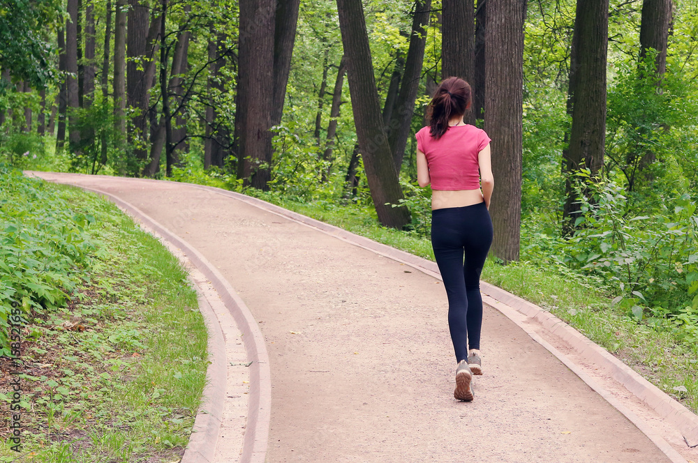 Young woman running down the road in the forest. Instagram Young woman running down the road in the forest. Instagram